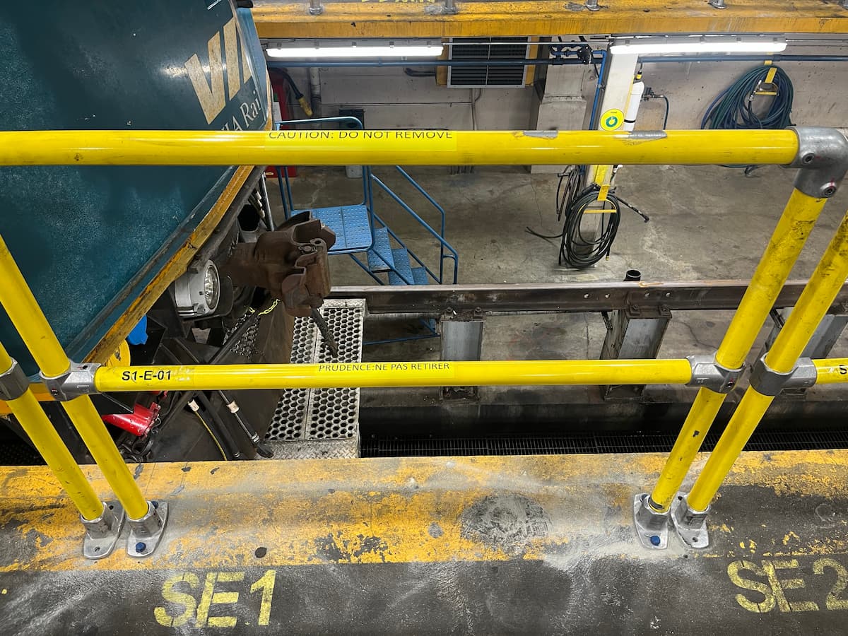 Upgraded safety railings on an industrial maintenance platform within a rail operations facility